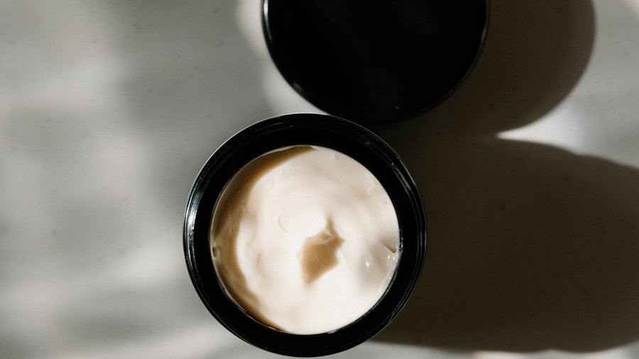 An open jar of SoBotanical Moisture Extreme Cream in dappled window light