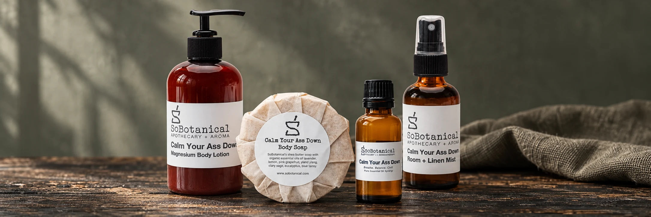 Calm Your Ass Down Magnesium Body Lotion, Body Soap, essential oil blend and Room + Linen Mist on weathered wood