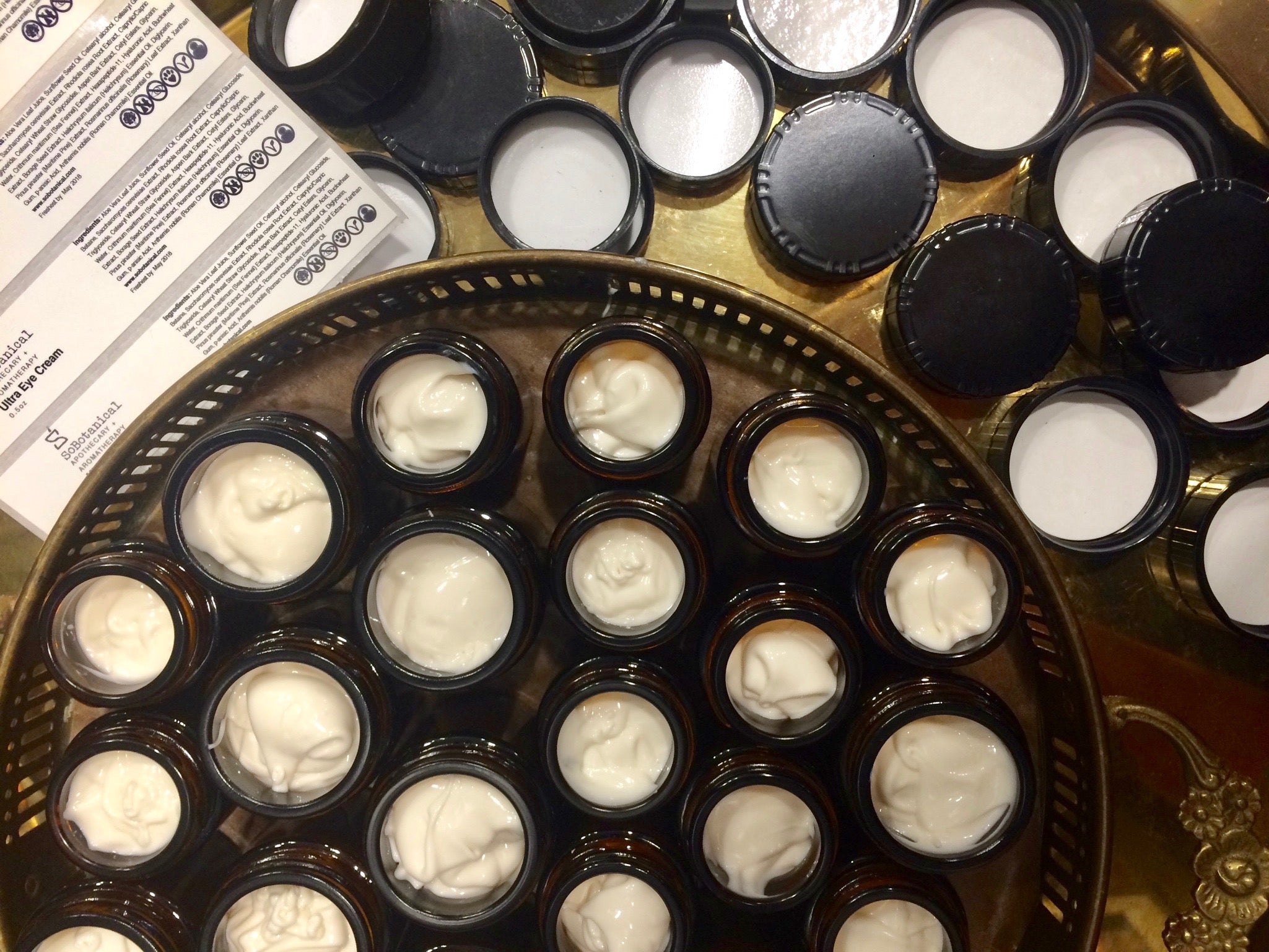 Open jars of freshly made cream before labelling